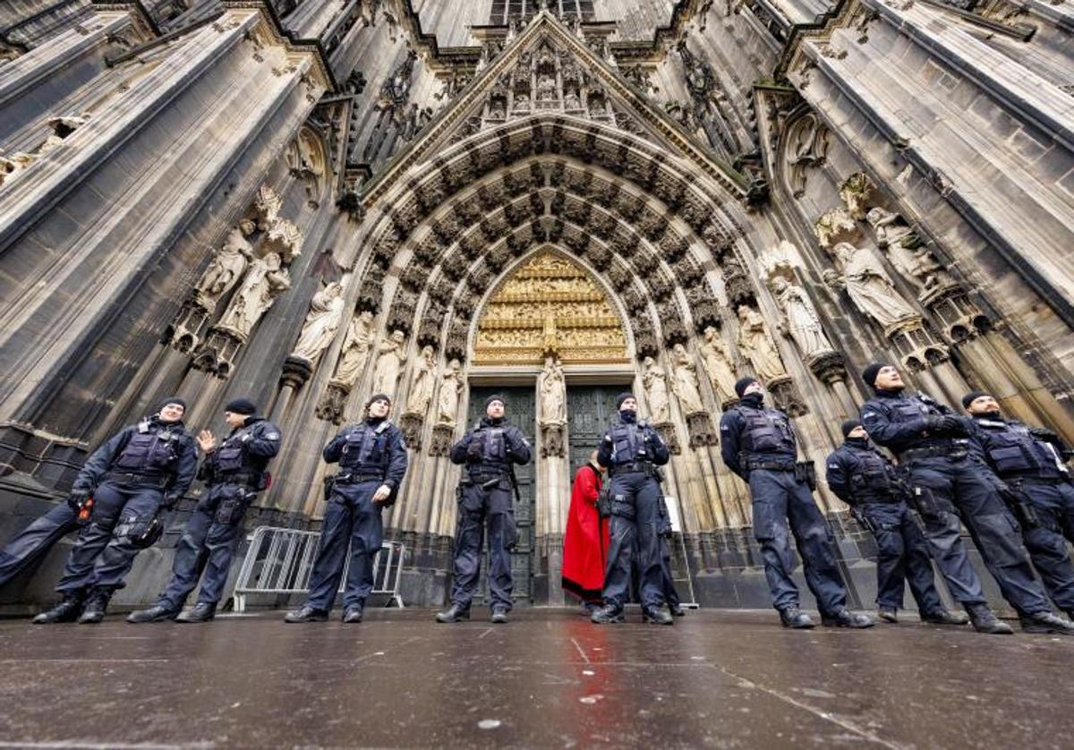 Varios policías vigilan a las puertas de la catedral de Colonia este domingo, después de que las autoridades reforzaran las medidas de seguridad de la catedral de esta ciudad del oeste de Alemania debido a una supuesta amenaza terrorista y revisará esta Nochebuena a todos los fieles y visitantes que accedan al icónico monumento