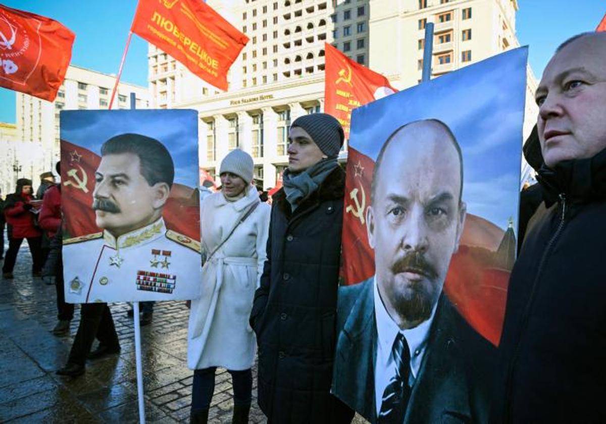 Los partidarios del comunismo ruso apoyan las historias de los líderes soviéticos Vladimir Lenin (derecha) y Joseph Stalin, antes de una ceremonia de colocación de flores en el mausoleo del fundador del estado soviético Vladimir Lenin para conmemorar el centenario de su muerte.