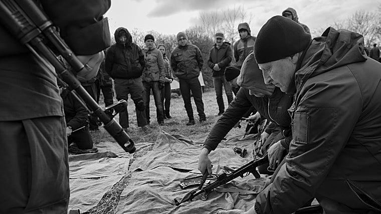 Un grupo de civiles que se alista para formar parte del Ejército ucraniano aprende a montar y desmontar un fusil