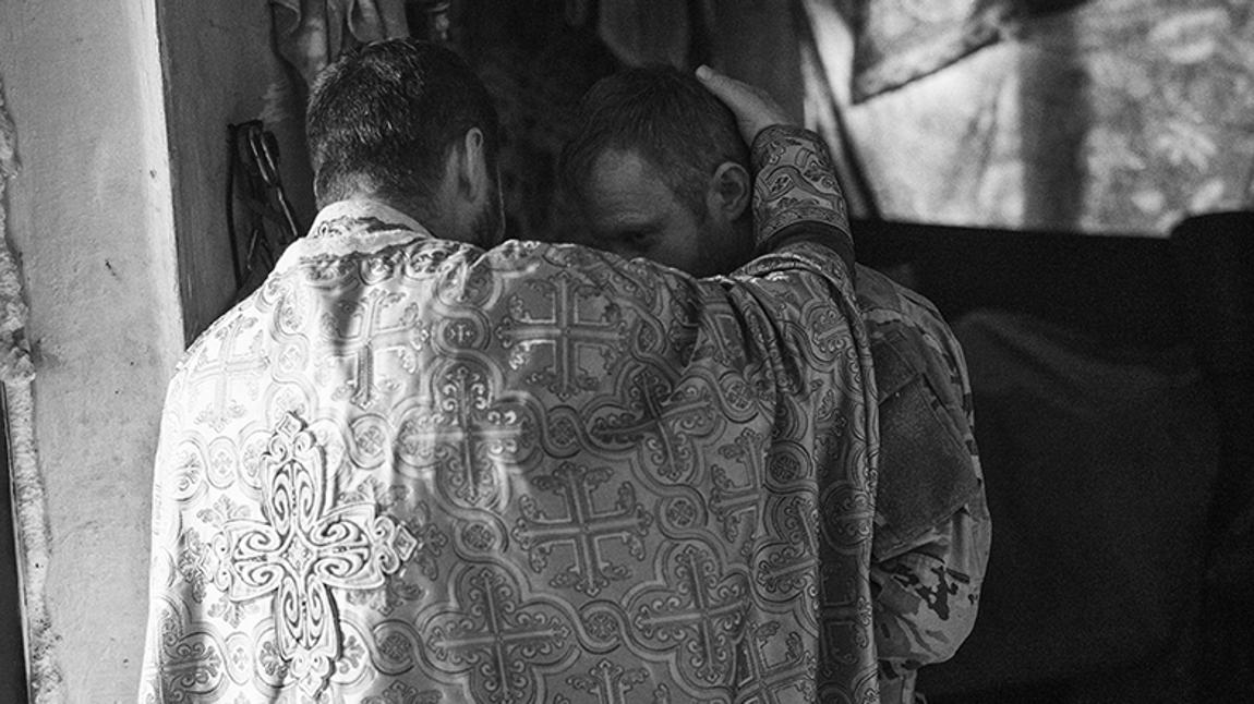 Chasiv Yar - Donestk: el Padre Ivan durante un a confesión a un soldado de la Brigada 80 en una base de Chasiv Yar en el frente de Bakhmut