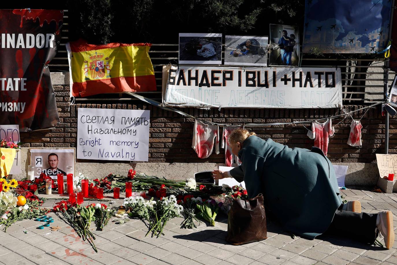 Una mujer coloca flores frente a la embajada rusa en Madrid