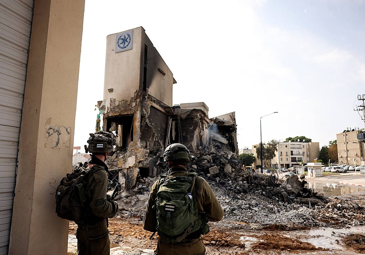 Soldados israelíes observan los restos de una comisaría de policía tras una infiltración masiva de pistoleros de Hamás desde la Franja de Gaza, en Sderot
