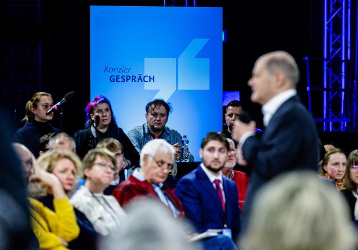Los participantes escuchan al Canciller alemán Olaf Scholz hablar durante un evento llamado 'Chancellor Talk' con ciudadanos en Dresde