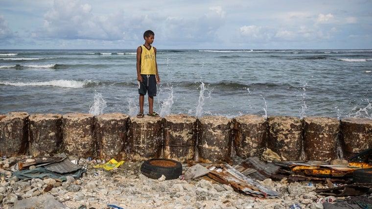 Frank, de 13 años, en Islas Marshall, sobre un rompeolas artificial que protege a su familia de la subida del agua