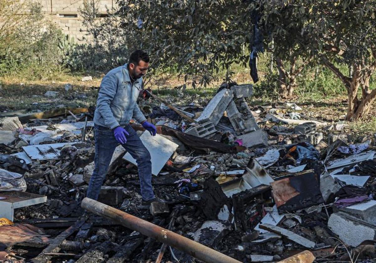 Un palestino busca sus pertenencias entre los escombros de las casas destruidas por los bombardeos israelíes en Rafah