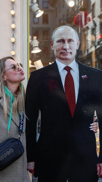 Una mujer se hace fotos junto a un Putin de cartón