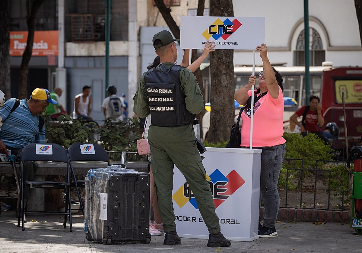 Trabajadores de Consejo Nacional Electoral (CNE) y miembros de la Guardia Nacional arman un puesto de registro electoral en Caracas
