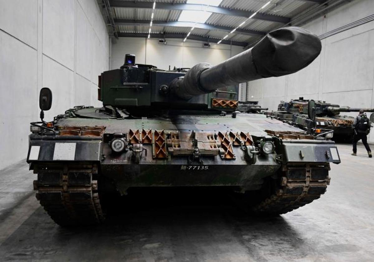 Los tanques Leopard 2 aparecen en una línea de producción mientras la Canciller alemana y el Ministro de Defensa alemán visitan el futuro sitio de una fábrica de armas