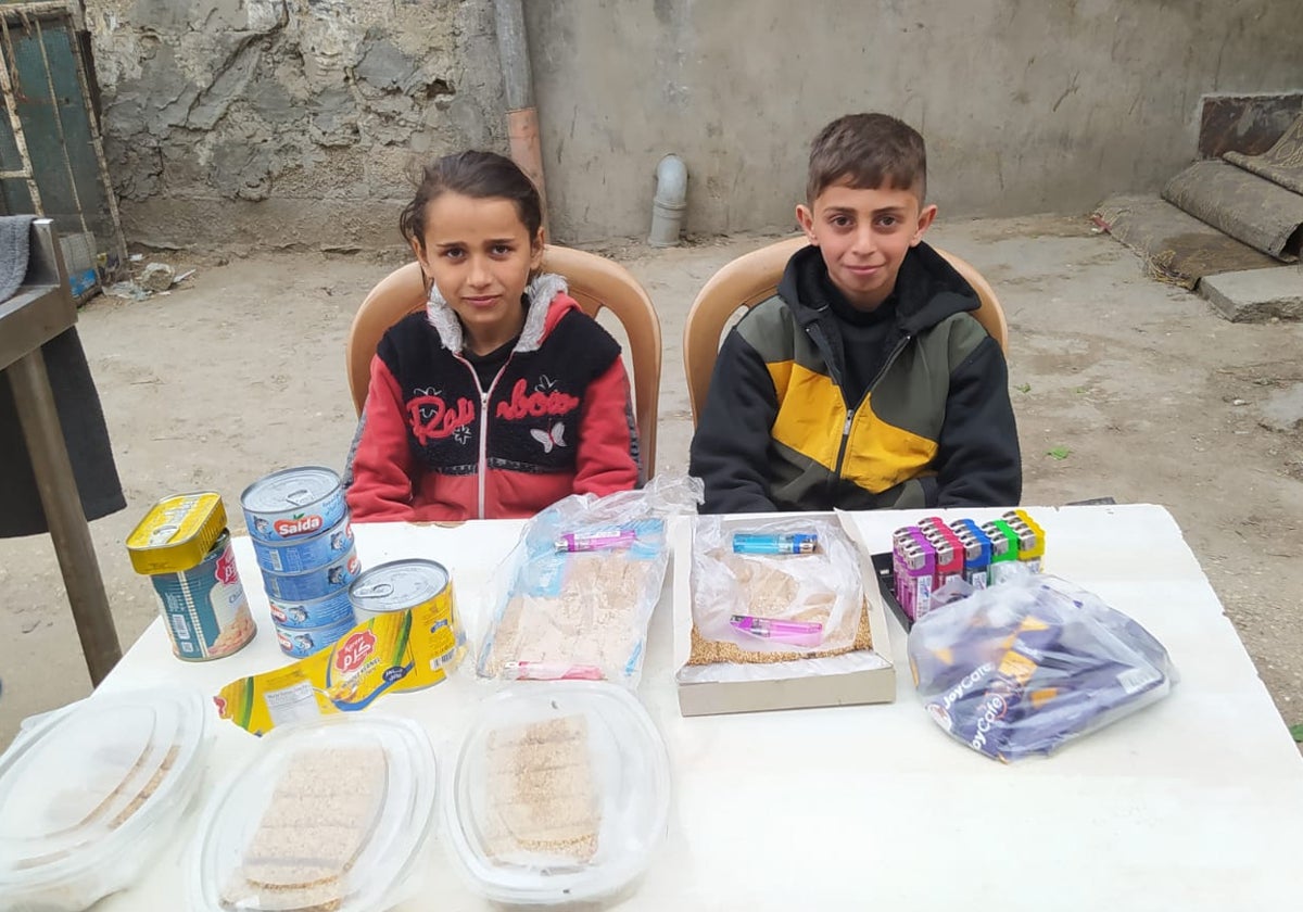 Anas Obid y Ayah Obid han cambiado el pupitre por una mesa en la que ofrecen mecheros, alguna lata de conserva y una especie de empanadas caseras