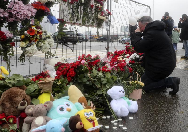 La gente llora y lleva flores en la sala de conciertos Crocus City Hall tras el ataque terrorista