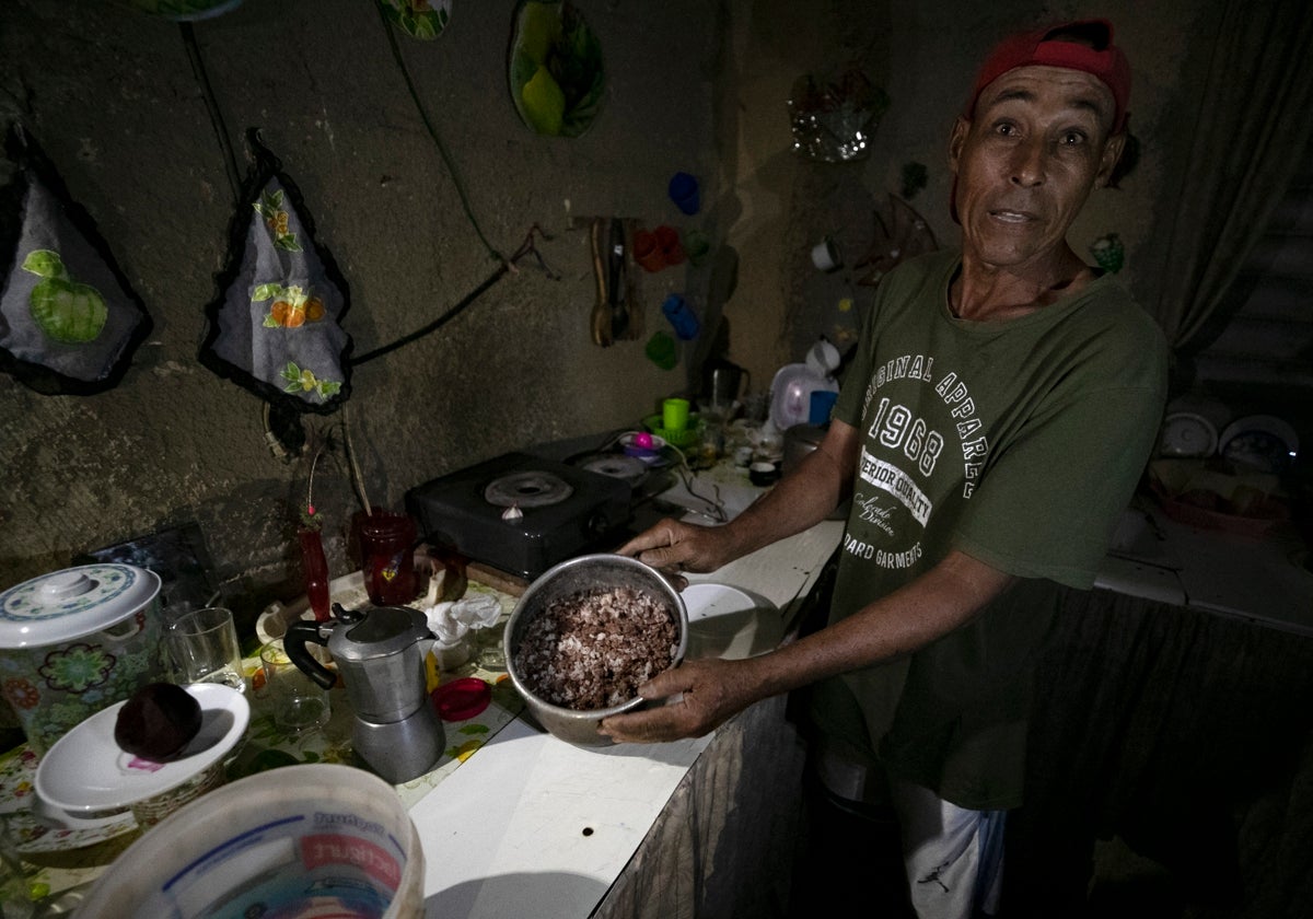 Un hombre muestra la comida estropeada por falta de frio, durante un apagón, en el poblado de Santa Marta, Varadero