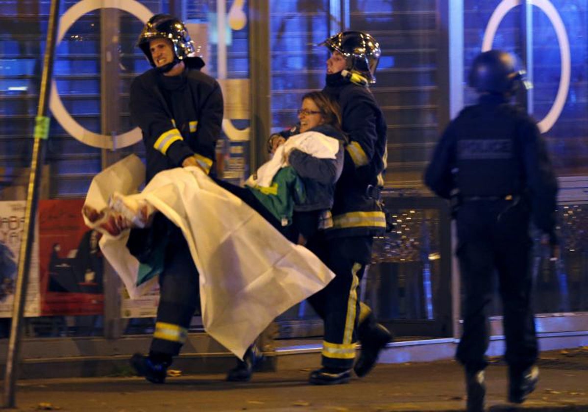 Bomberos evacúan heridos de la sala de conciertos Bataclan tras los atentados en París en noviembre de 2015