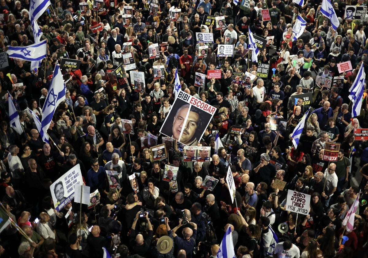 Familiares y partidarios de rehenes israelíes retenidos por Hamas en Gaza sostienen carteles y banderas israelíes durante una manifestación de protesta