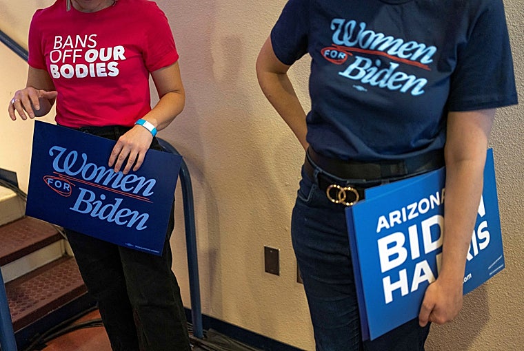 Mujeres vestidas con camisetas y carteles en apoyo de los derechos reproductivos y del presidente estadounidense Joe Biden ante un discurso de la vicepresidenta Kamala Harris tras el fallo del martes del Tribunal Superior de Arizona que confirma una prohibición del aborto de 160 años de antigüedad, en un evento en Tucson, Arizona