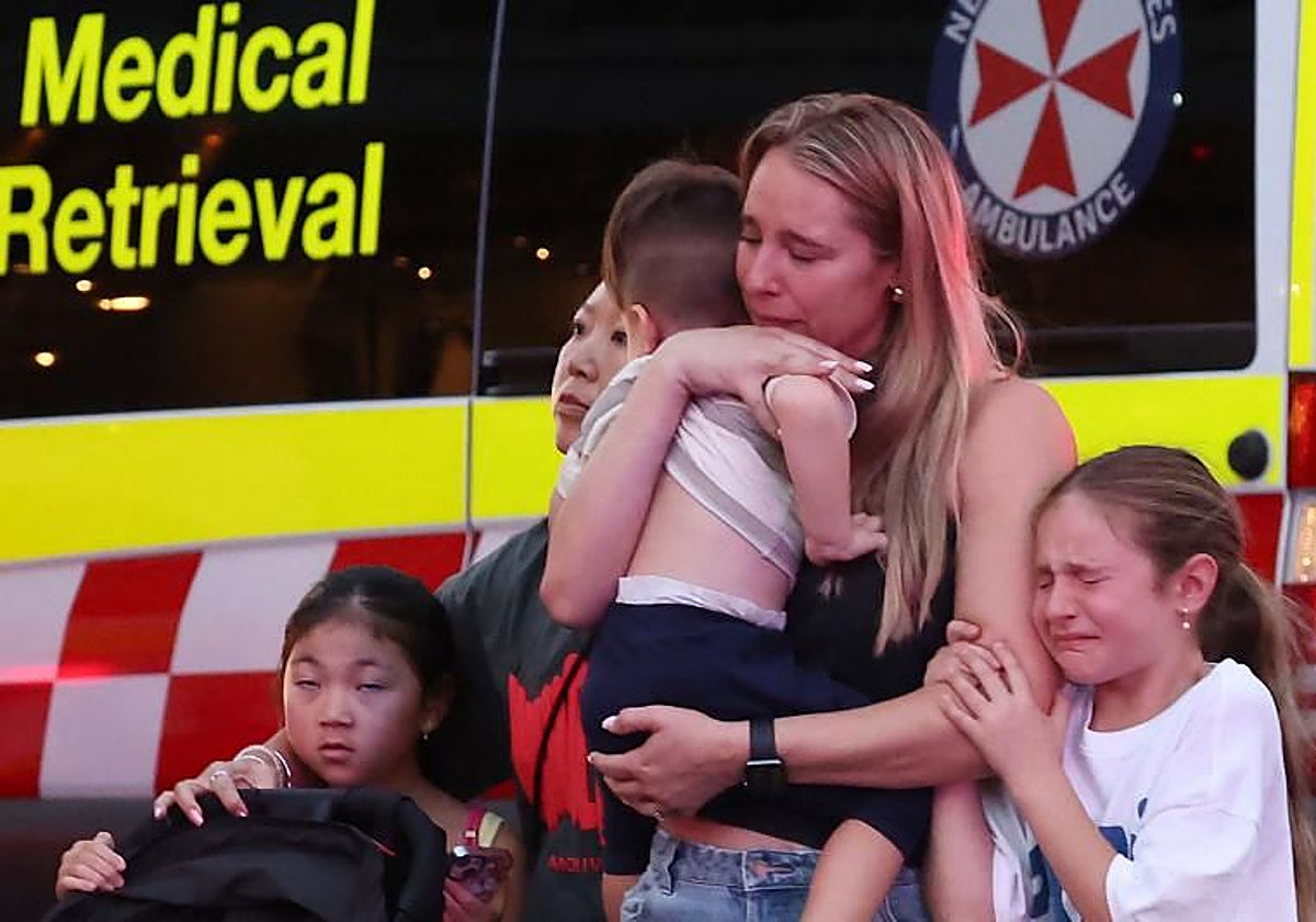 Una madre con sus hijos pequeños son evacuados del centro comercial Bondi Junction, en Sídney, tras el apuñalamiento masivo
