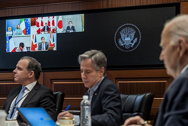 Joe Biden (der.) hablando con líderes del G7, en pantalla, este domingo desde la Casa Blanca en Washington