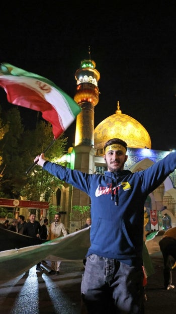 Manifestantes iraníes ondean una bandera palestina mientras se reúnen en la Plaza Palestina de Teherán tras el ataque contra Israel