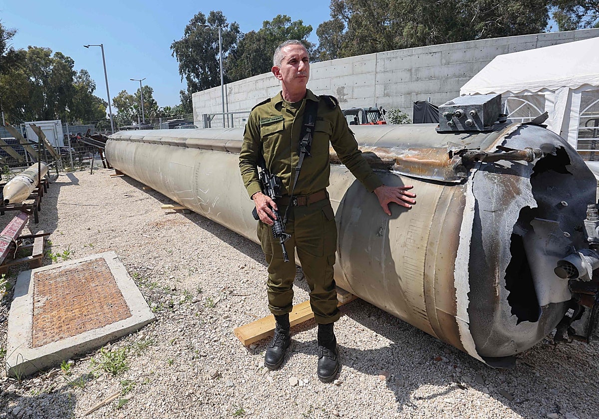 El portavoz militar israelí Daniel Hagari es fotografiado junto a un misil balístico iraní lanzado el fin de semana
