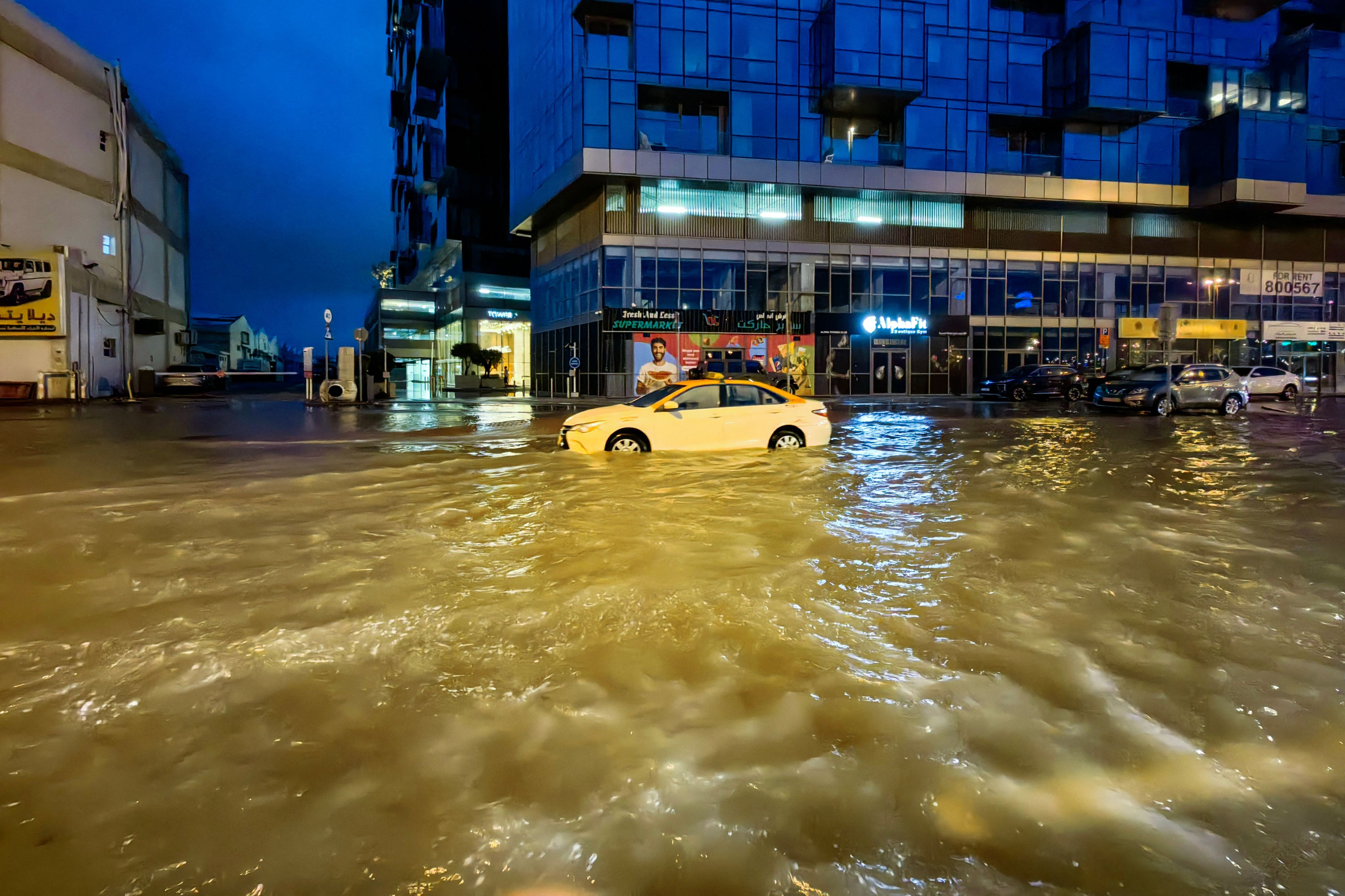 Un taxi circula en medio de una carretera inundada tras las fuertes lluvias en Dubái.