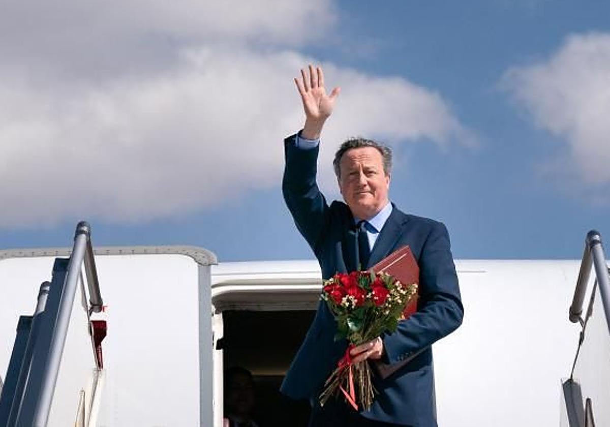 El secretario de Asuntos Exteriores del Reino Unido, David Cameron, saluda mientras sube a su avión en Mongolia