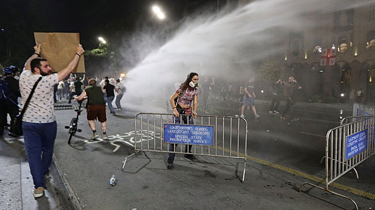 Los agentes del orden utilizan un cañón de agua para dispersar a la multitud cerca del edificio del parlamento