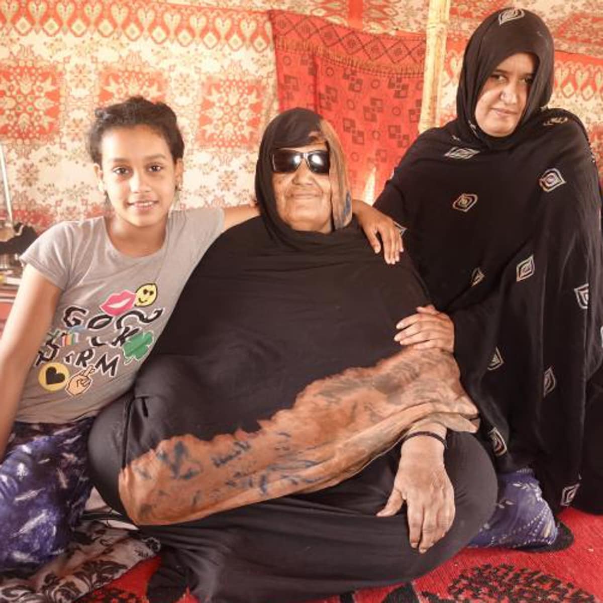 Lamina (en el centro), su hija Jade y su nieta Maga en el campo de refugiados de Auserd