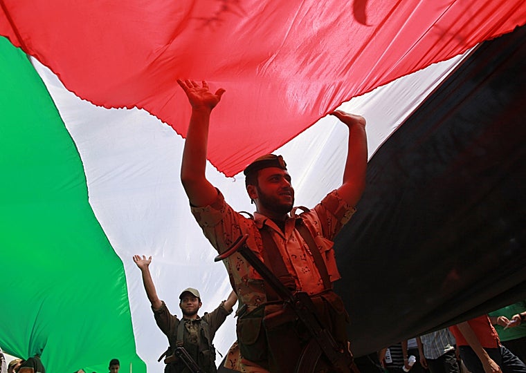 Miembros de Hamás en Gaza sostienen una gran bandera palestina, en una foto de archivo