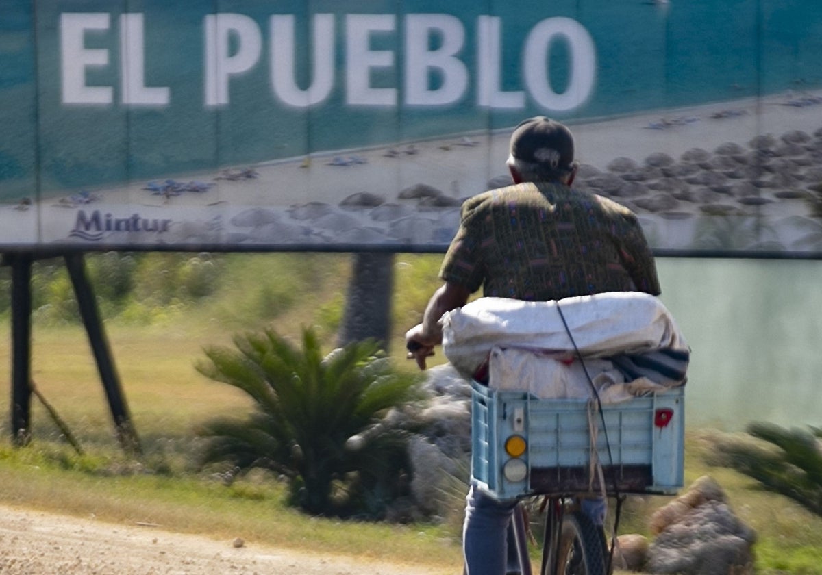 Un hombre pasa junto a un cartel publicitario en Varadero (Cuba)