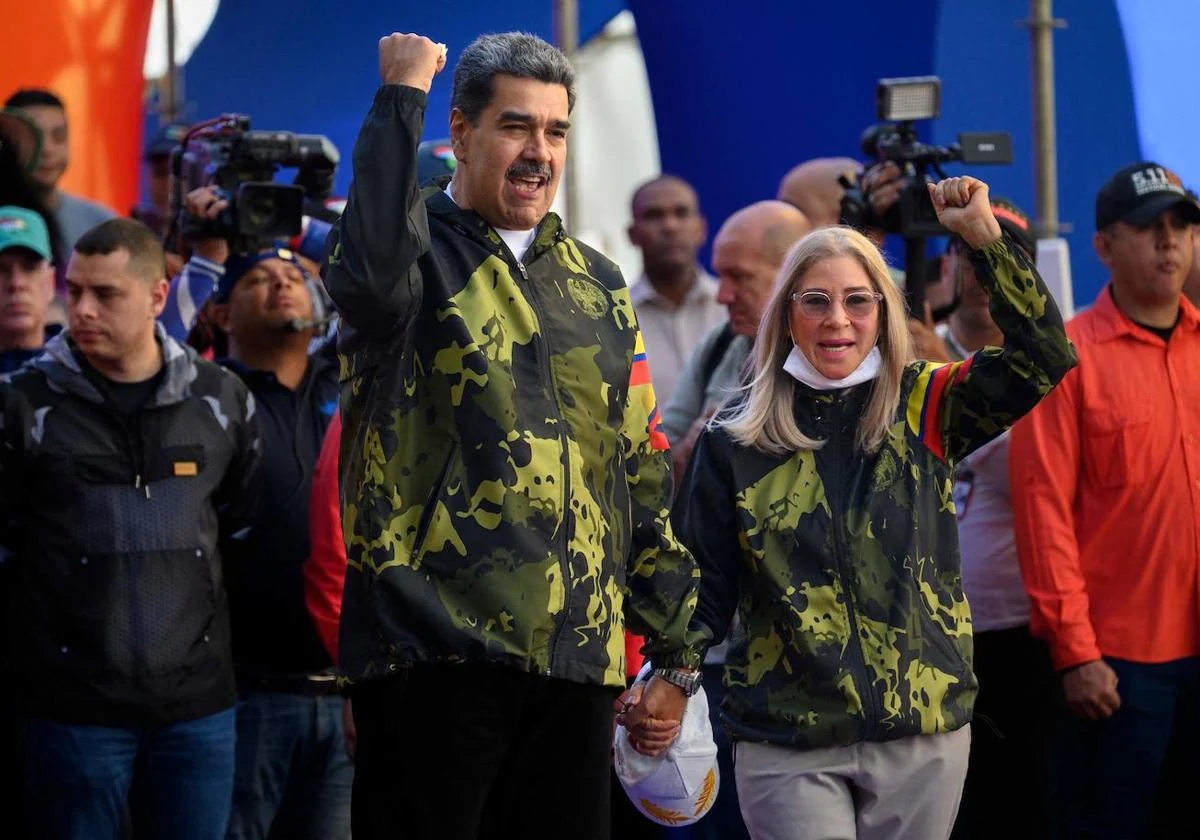 El presidente venezolano, Nicolás Maduro (izq.) y la primera dama Cilia Flores (der.), saludan a sus partidarios
