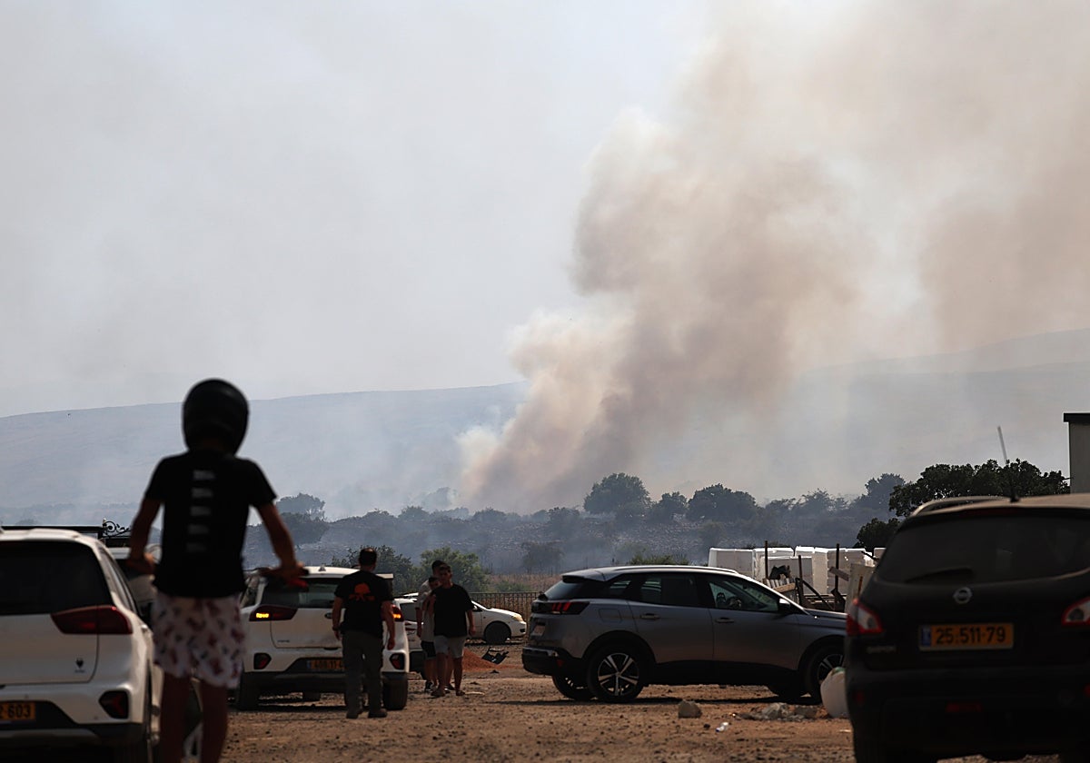 Habitantes israelíes de la zona observan cómo se eleva el humo de un incendio provocado por ataques desde el Líbano