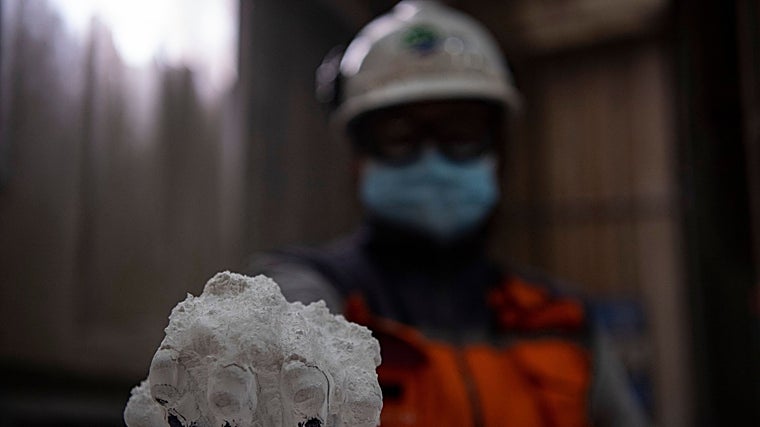 Un trabajador del triángulo del litio con un puñado de este mineral puro