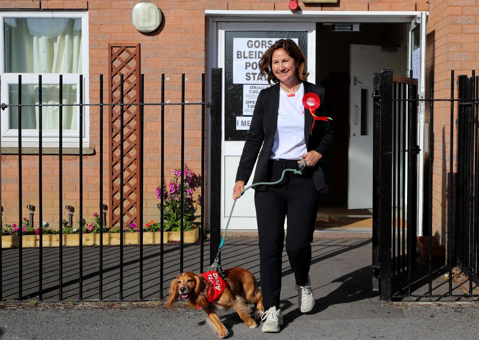 Anna McMorrin, candidata del Partido Laborista por Cardiff North, y su perro Cadi salen de un colegio electoral en el Centro Comunitario Llandaff North en Cardiff