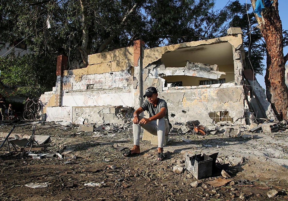 Hombre palestino se sienta sobre los escombros de la escuela bombardeada por Israel