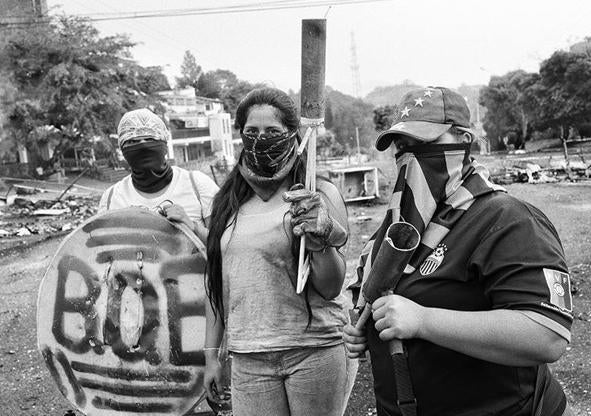 Imagen secundaria 1 - En la primera imagen, grafiti contra Chávez en Venezuela; en la segunda, seguidores durante su funeral. En la última instantánea, estudiantes antigubernamentales en San Cristóbal