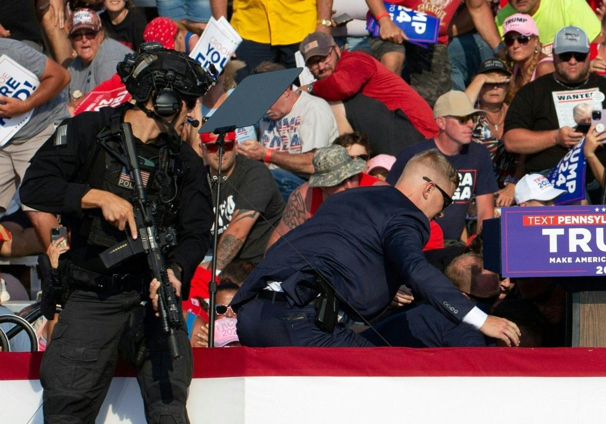 Un agente de seguridad observa cómo cubren a Trump tras los disparos.
