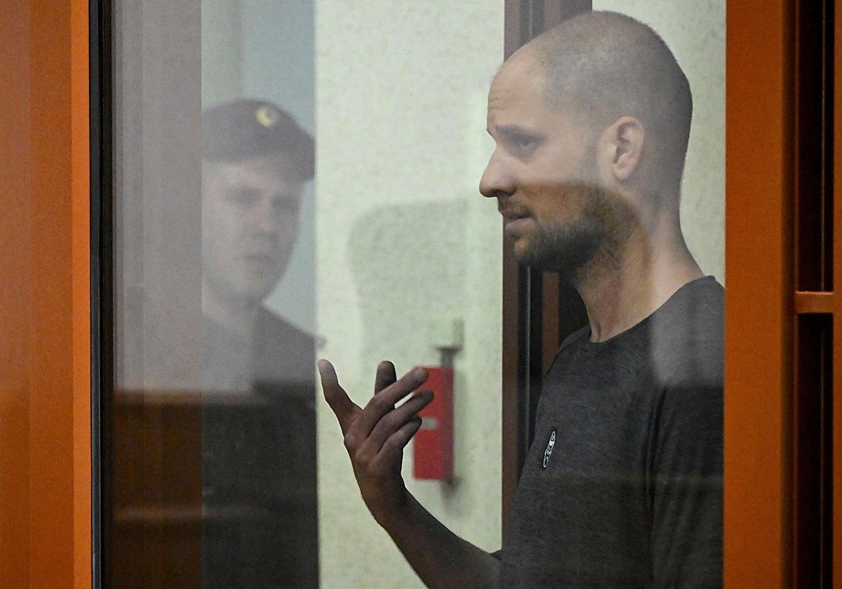 El periodista estadounidense Evan Gershkovich , acusado de espionaje, hace un gesto dentro de una jaula de cristal para acusados durante el anuncio del veredicto en el Tribunal Regional de Sverdlovsk en Ekaterimburgo