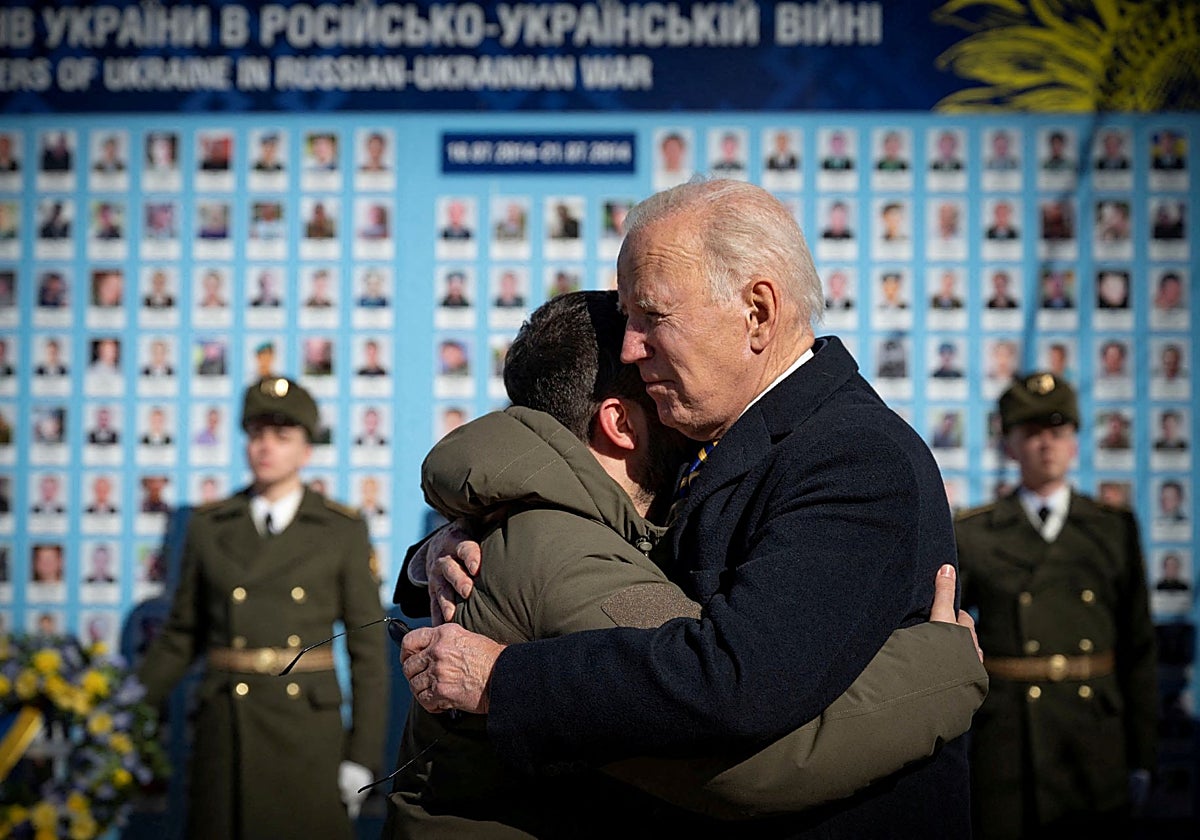 Biden abraza a Zelenski mientras visitan el Muro del Recuerdo para rendir homenaje a los soldados ucranianos muertos, en febrero de 2023