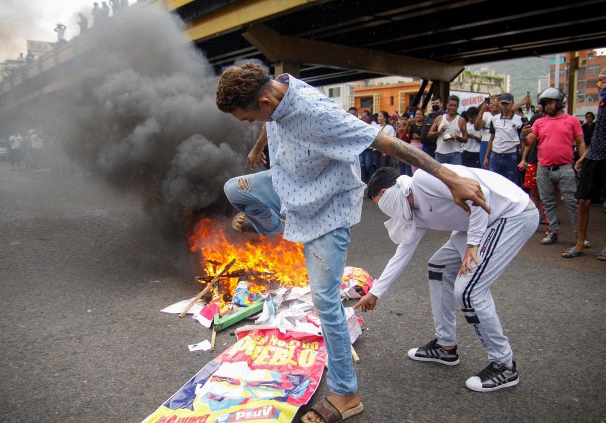 Los manifestantes pisan un cartel de campaña del presidente de Venezuela, Nicolás Maduro, tras el resultado electoral