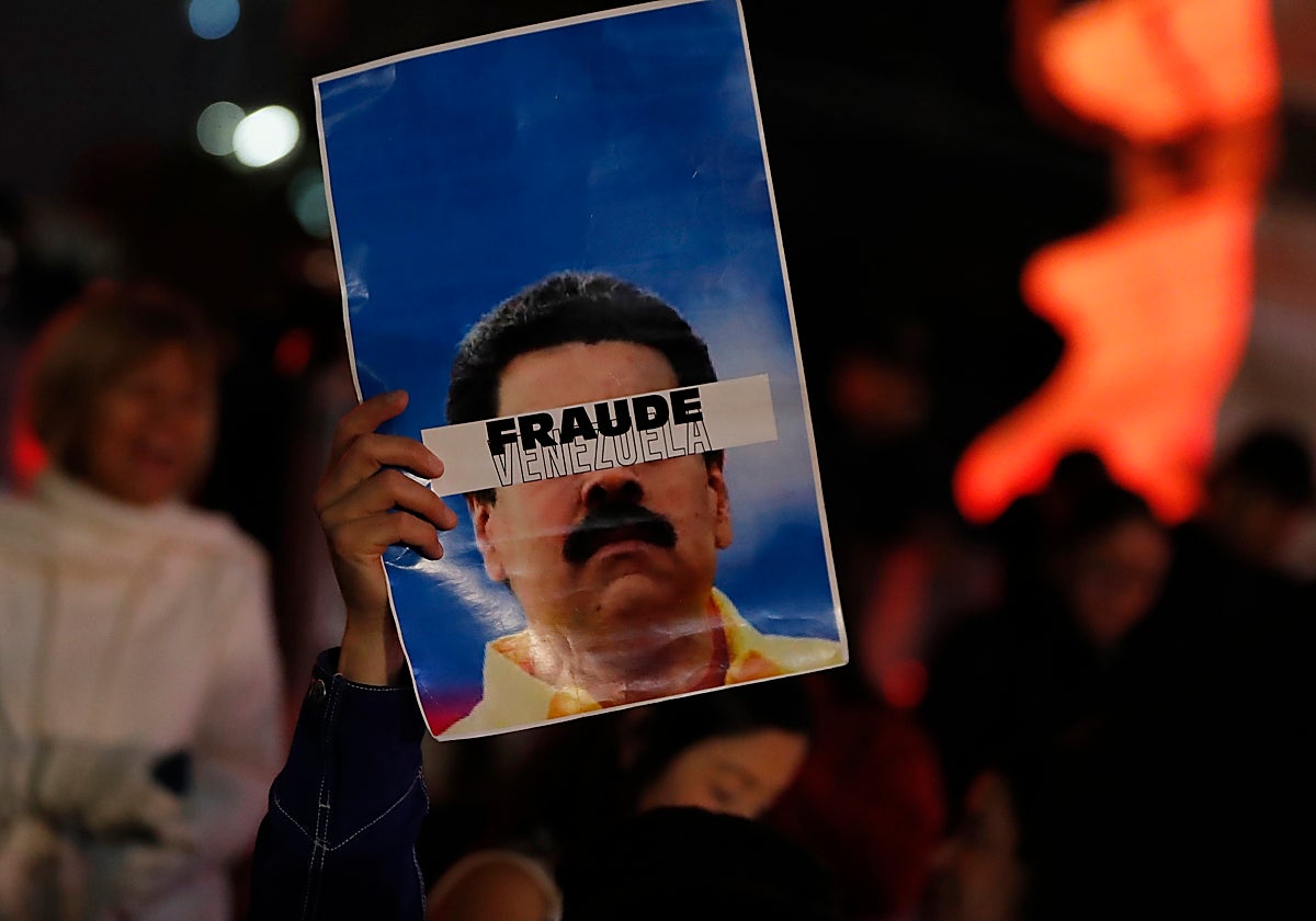 Una persona sostiene un cartel que dice «Fraude Venezuela» durante una protesta este martes en Ciudad de México (México)