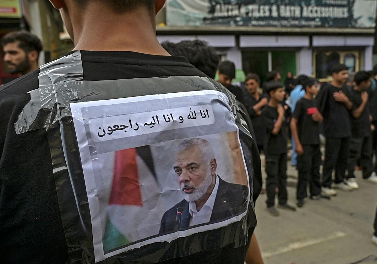 Una foto del líder de Hamás, Ismael Haniyeh, pegada en la espalda de una persona en una procesión fúnebre