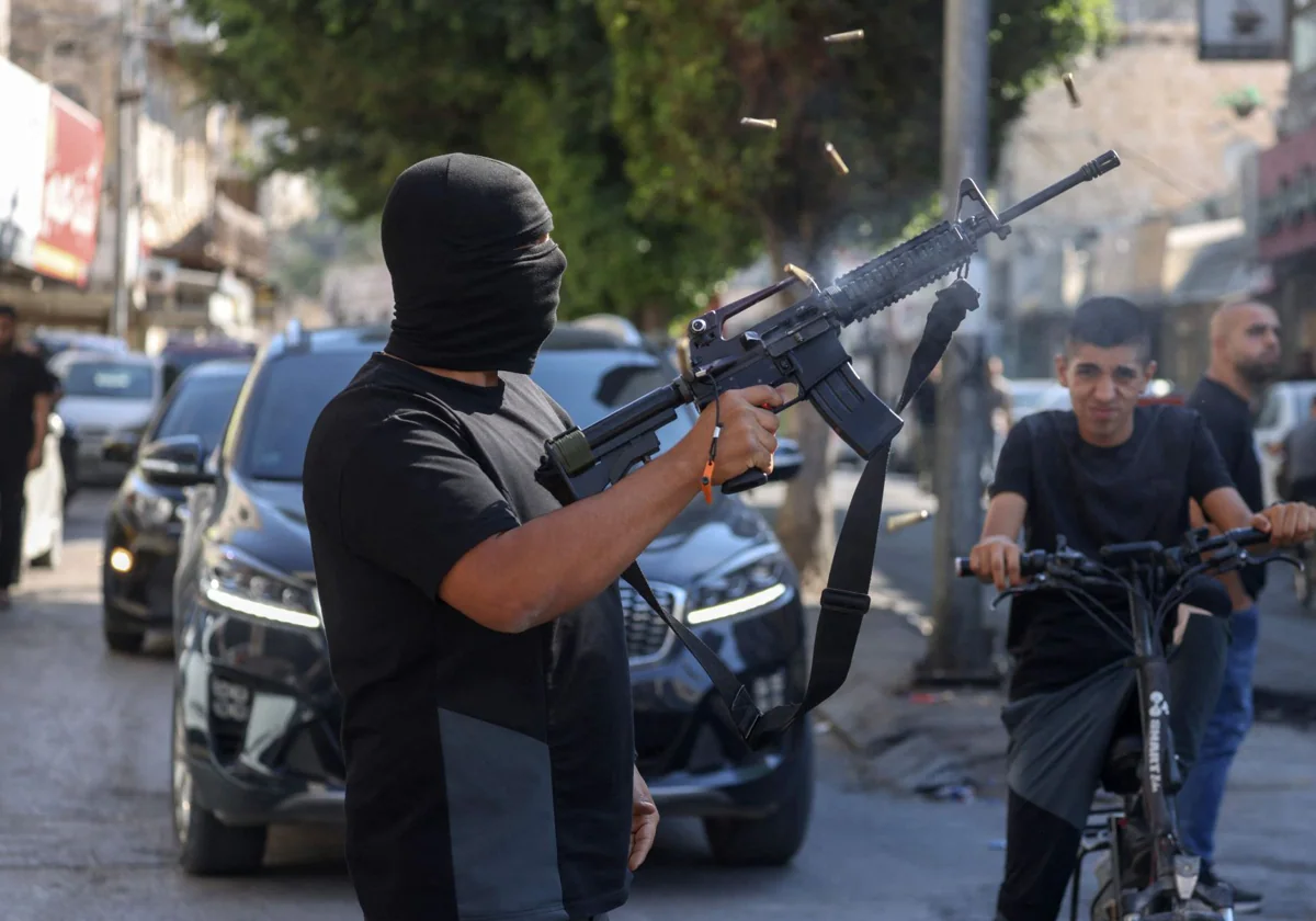 Un hombre dispara su fusil durante los funerales de cinco palestinos celebrados en Cisjordania