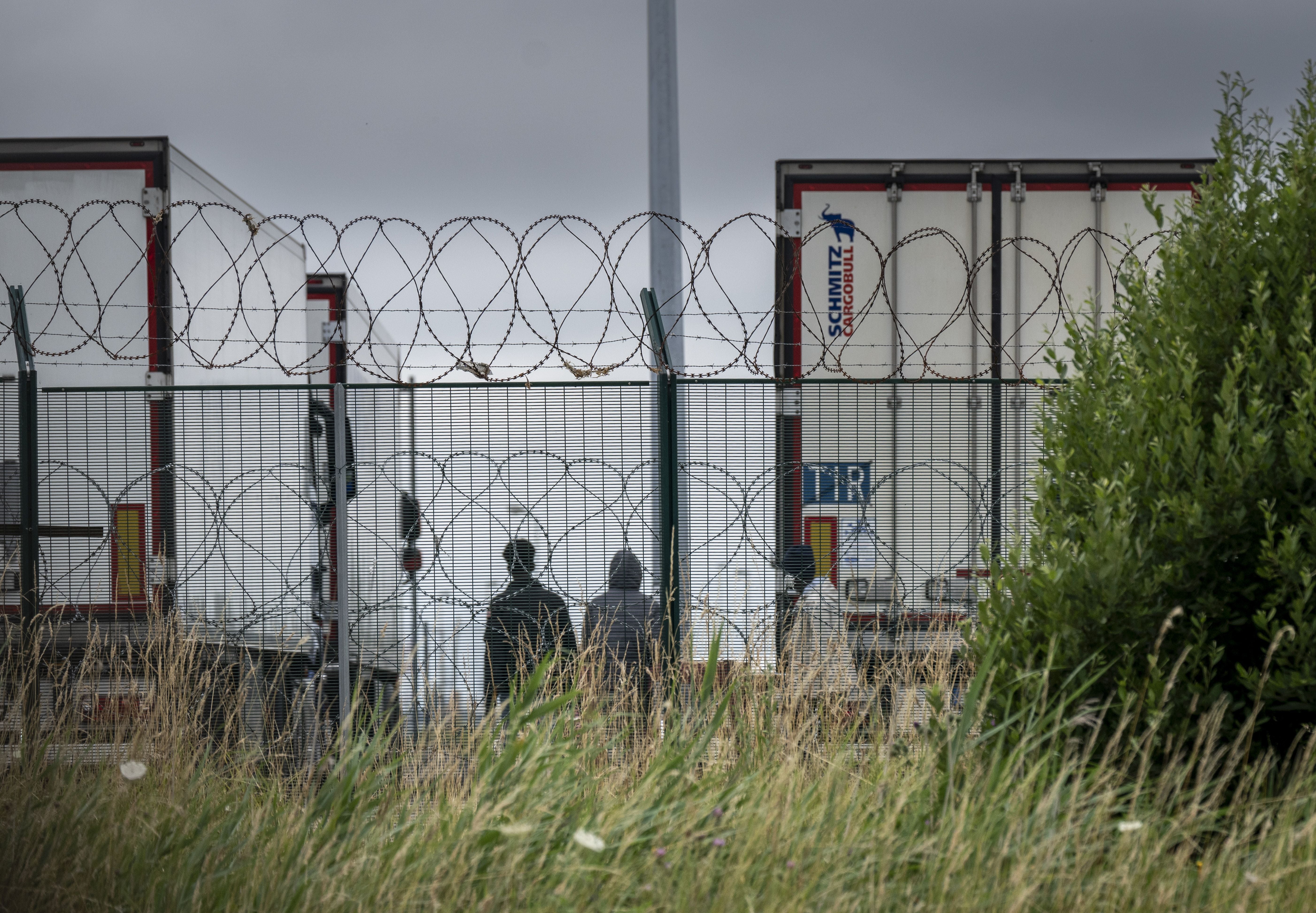 Un grupo de migrantes subsaharianos intentan abordar un camión para cruzar ilegalmente el Canal