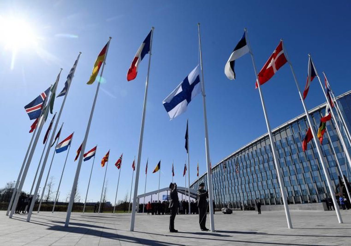 El personal militar finlandés instala la bandera nacional finlandesa en la sede de la OTAN en Bruselas