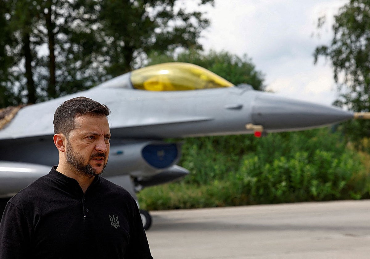 El presidente de Ucrania , Zelenskii, habla con los medios frente a un avión de combate F- 16 después de conmemorar el Día de las Fuerzas Aéreas de Ucrania