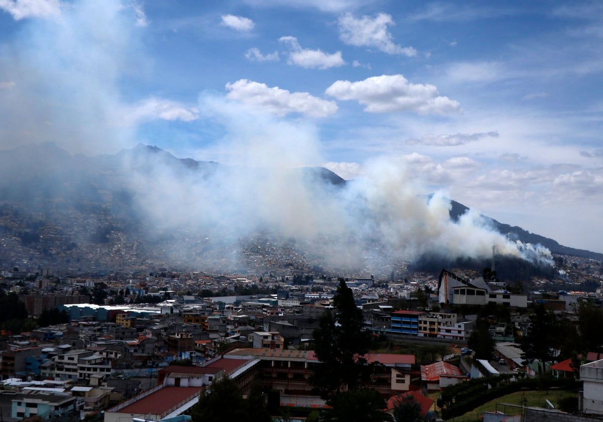 El humo se eleva sobre el cielo de Quito tras el incendio de una zona boscosa