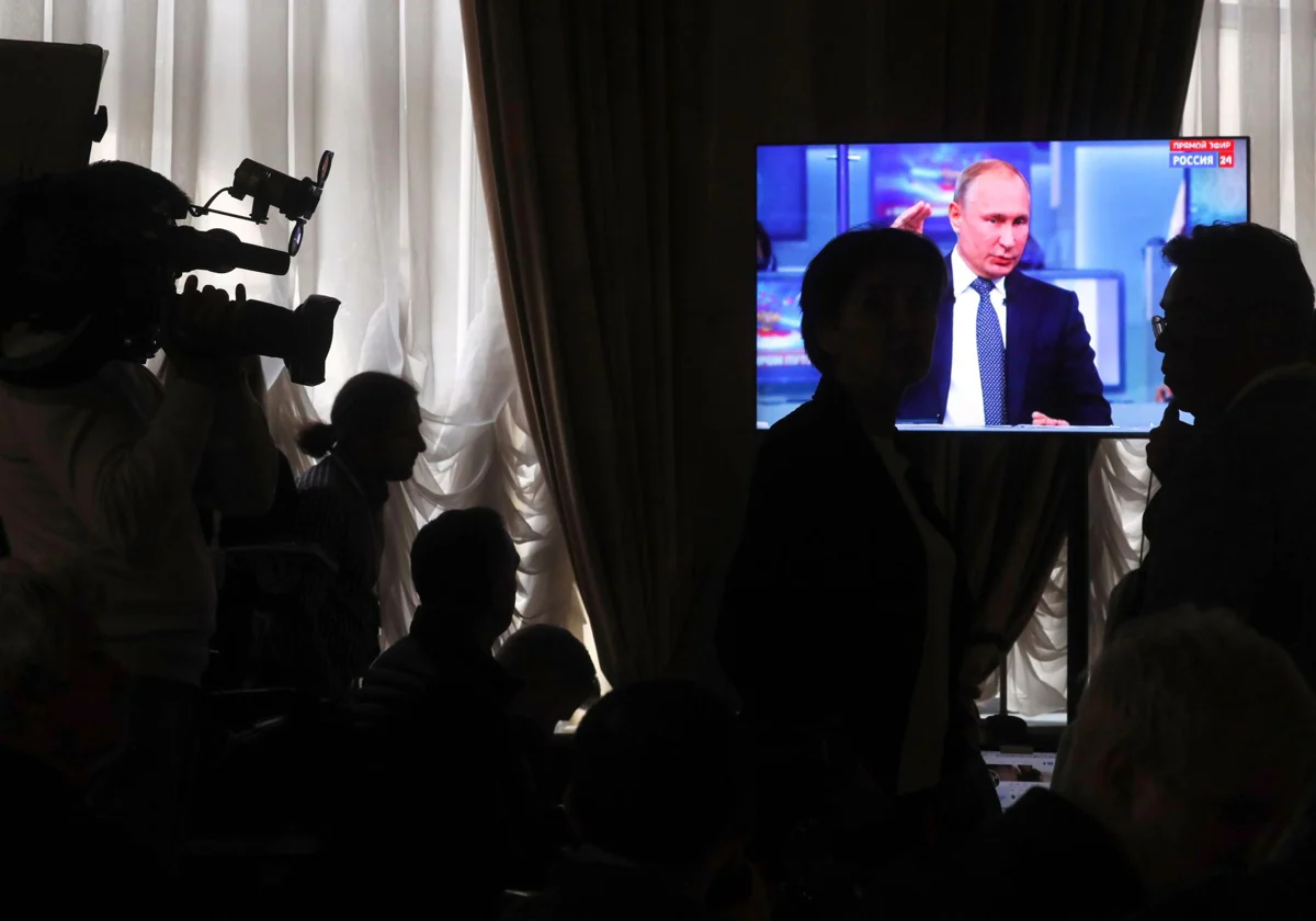 Unos periodistas observan una pantalla que muestra a Putin hablando durante una alocución