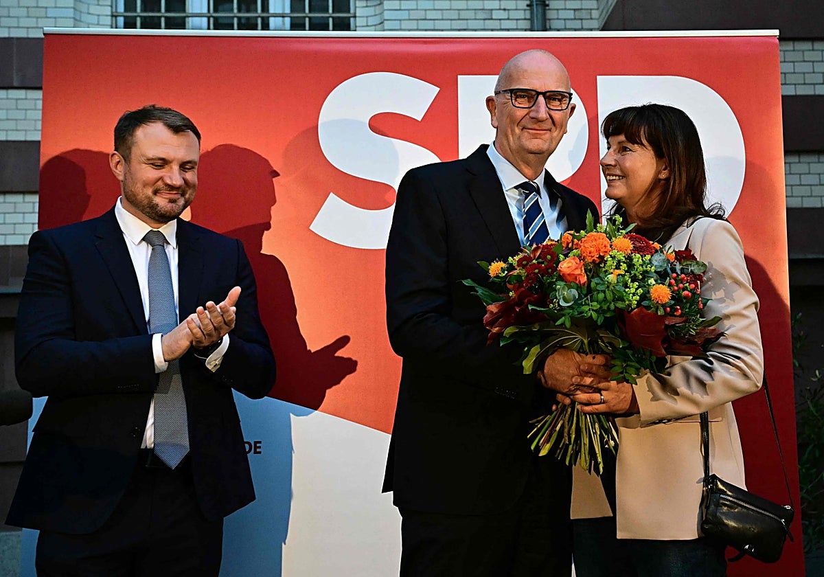 El primer ministro de Brandeburgo y principal candidato del SPD, Dietmar Woidke, y su esposa Susanne reaccionan después de la publicación de las encuestas a pie de urna en la sede del partido socialdemócrata SPD en Potsdam, este de Alemania