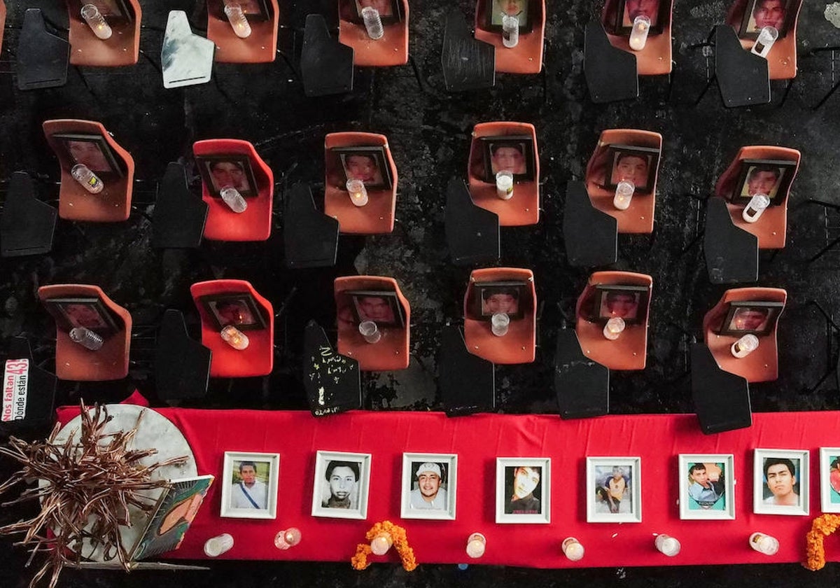 Escritorio con fotografías y velas de los estudiantes desaparecidos, en Tixtla, estado de Guerrero