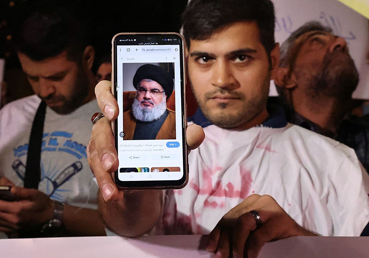 Un hombre muestra una fotografía de Nasralá en la pantalla de su teléfono móvil