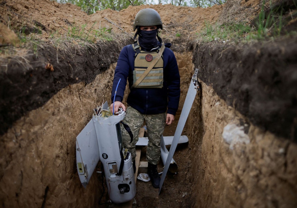 Un soldado ucraniano sostiene un dron derribado